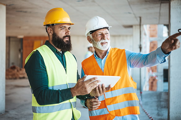 two construction workers looking over a project plan