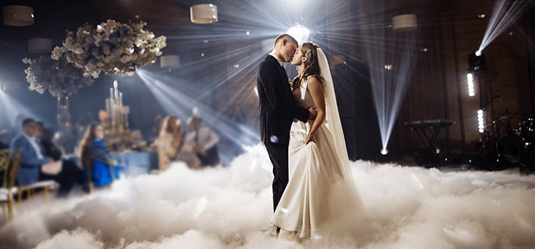A bride and groom kiss during a dance on their wedding day