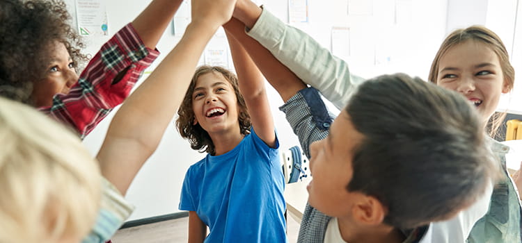 A group of students cheer and hold hands